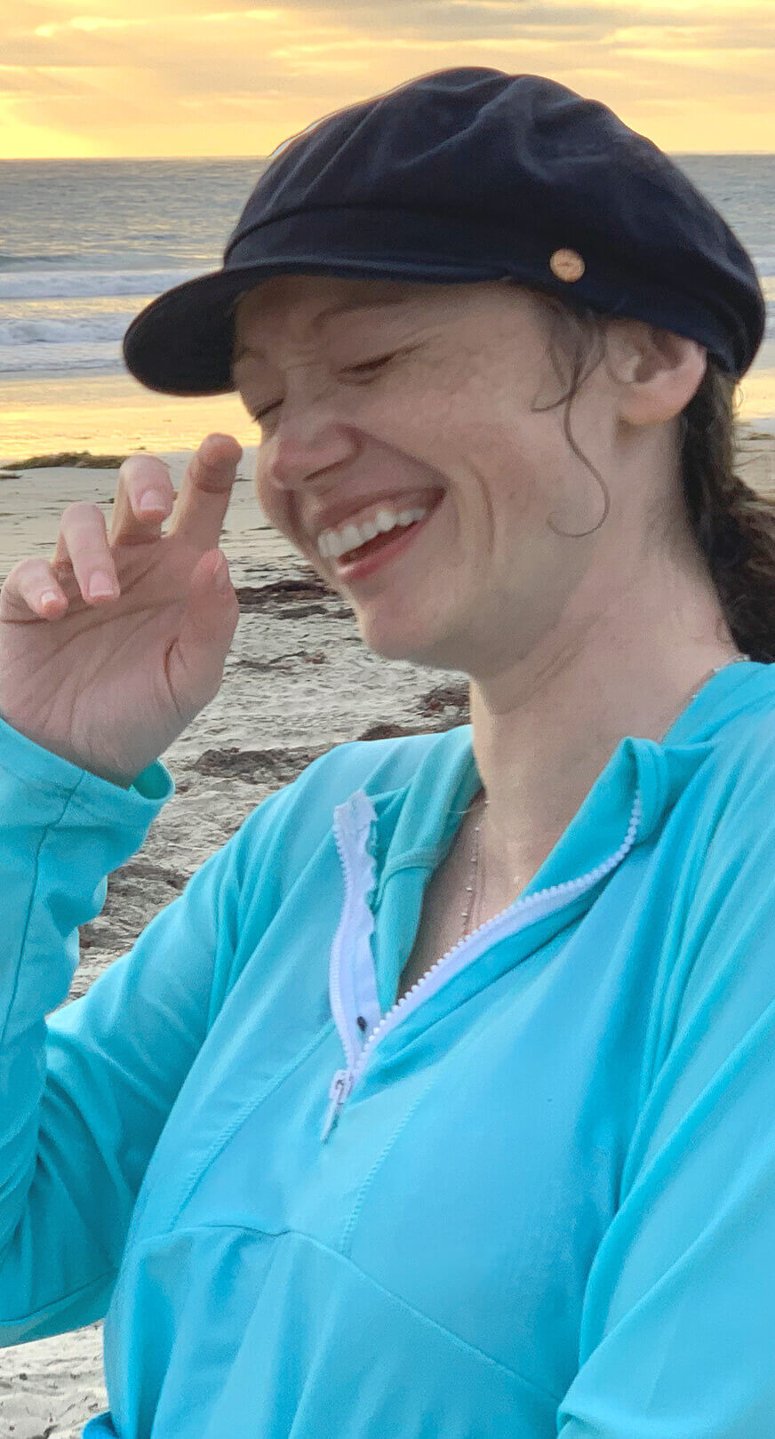 A photograph of Jennifer Gadus being a nerd on a beach.